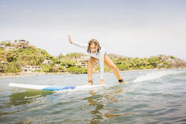 Mixed race girl surfing in waves