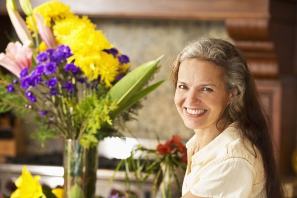 Hispanic woman with flowers in kitchen