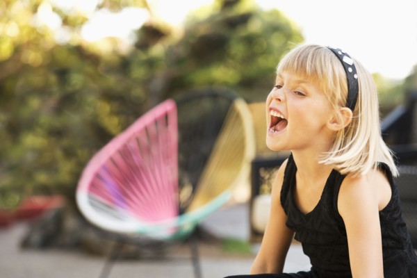 Caucasian girl shouting in backyard