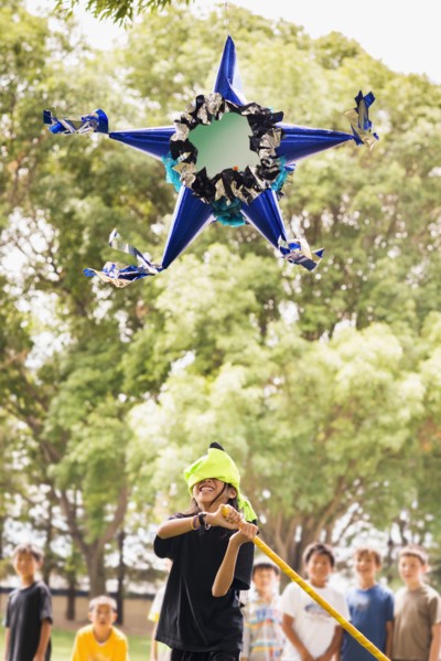 Blindfolded boy hitting pinata at party