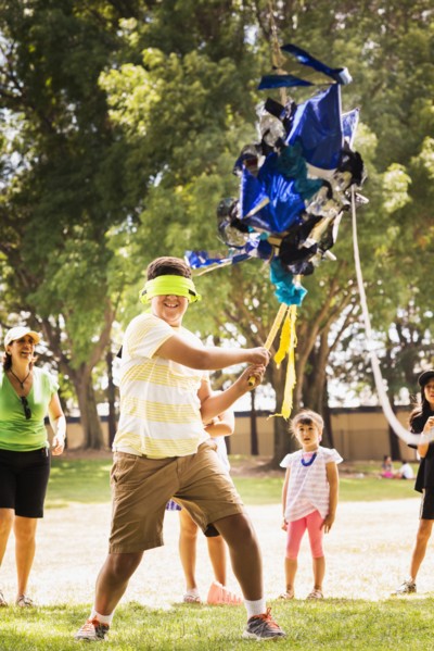 Blindfolded boy hitting pinata at party