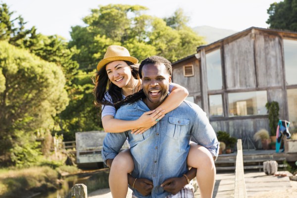 Man carrying girlfriend piggyback outdoors