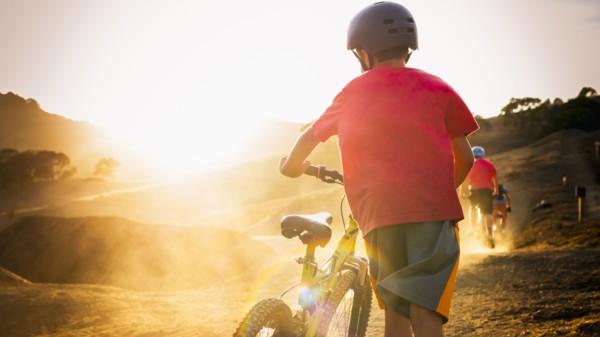 Mixed race boy riding dirt bike on track