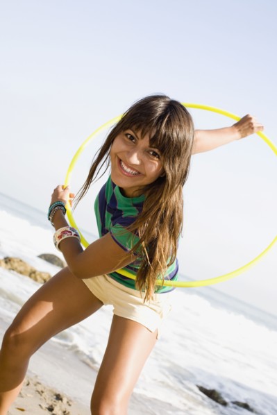 Woman playing with plastic hoop on beach