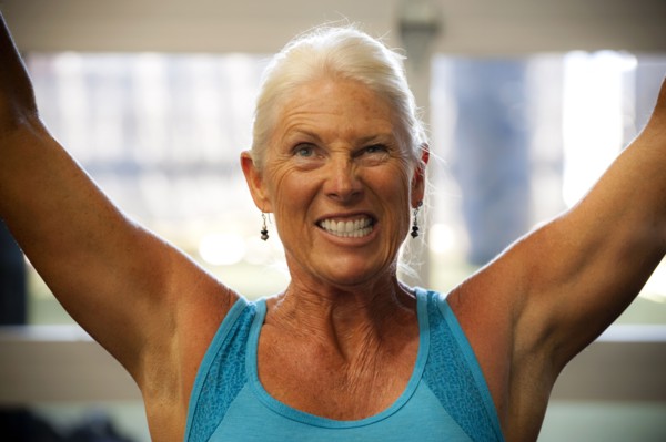 Grimacing older woman working out in gymnasium
