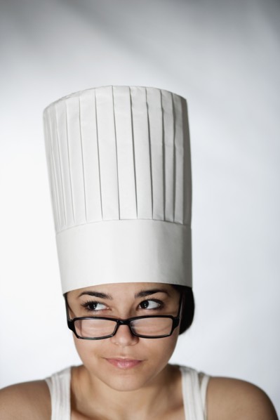 Hispanic woman in chef's hat and eyeglasses