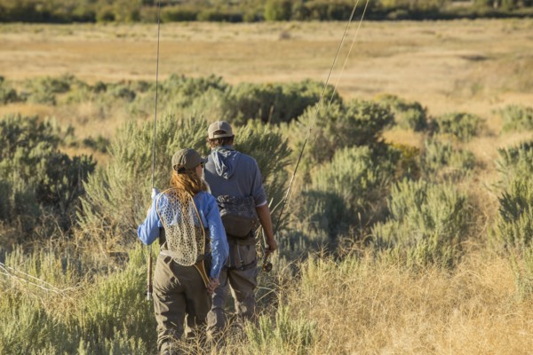 Caucasian couple with fishing gear in field