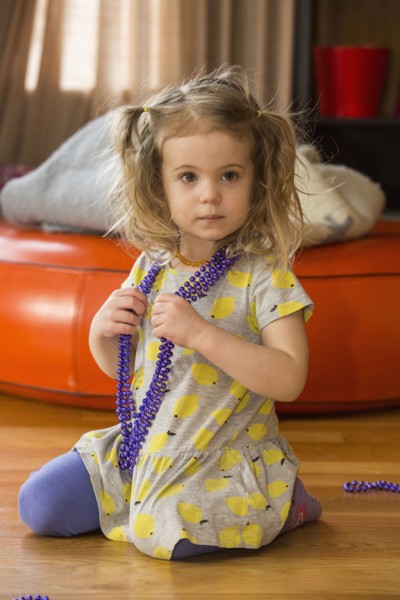 Caucasian preschooler girl playing dress-up with necklace