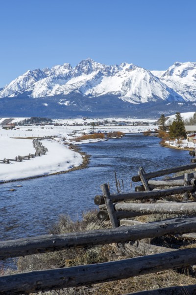 Snowy mountains and river in rural landscape