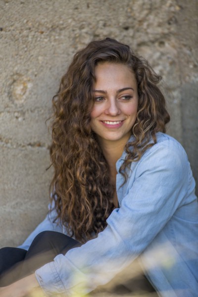 Caucasian woman sitting at concrete wall