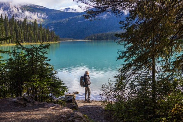 Caucasian man standing at mountain lake