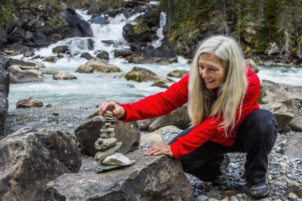Caucasian woman balancing stack of rocks