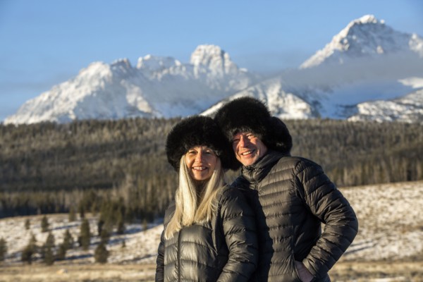 Caucasian couple smiling near mountains in winter
