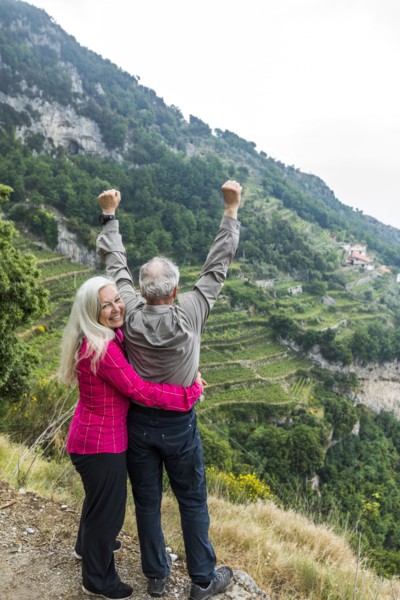 Caucasian couple celebrating on hill