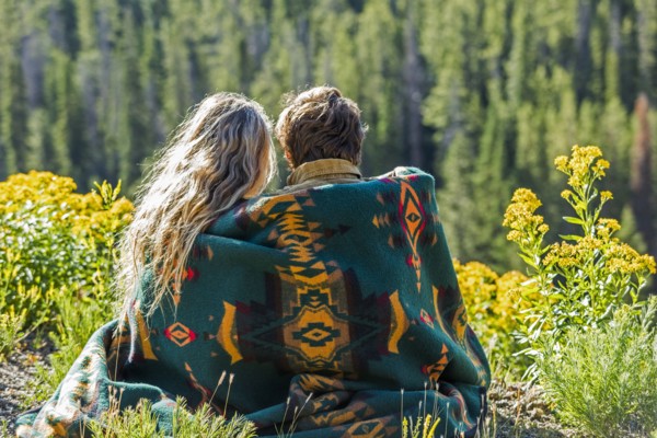 Caucasian couple wrapped in blanket admiring scenic view of landscape
