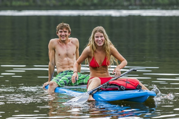 Caucasian couple straddling paddleboard