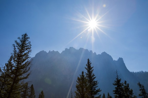 Sunbeams over trees near mountain