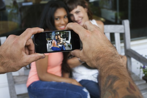 Man photographing women with cell phone