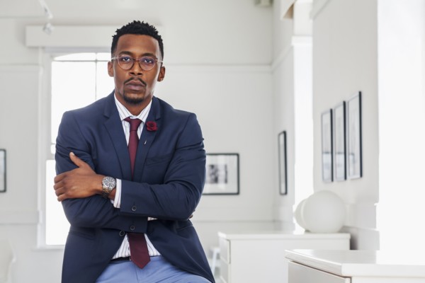 Black man with arms crossed in gallery