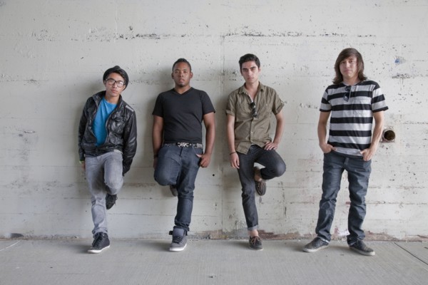 Serious teenage boys leaning against wall