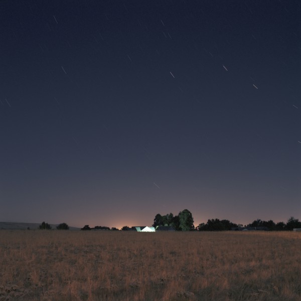 Stars and sunset over field