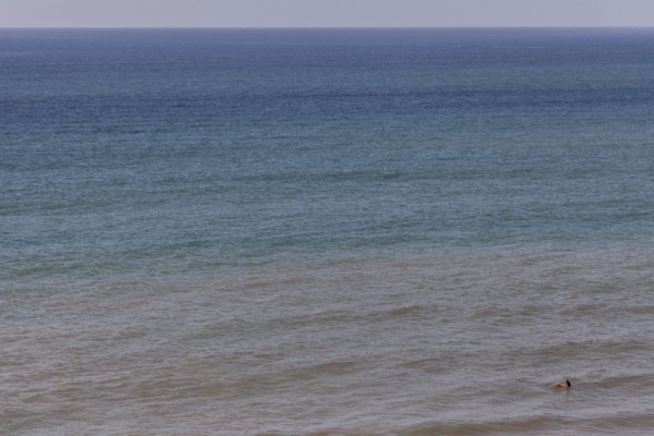 Aerial view of surfer floating on ocean waves