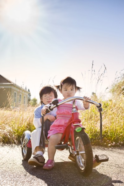 Chinese brother and sister riding tricycle