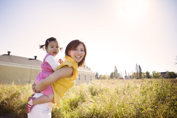 Chinese mother giving daughter piggyback ride