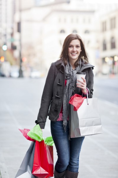 Mixed race woman shopping and drinking coffee