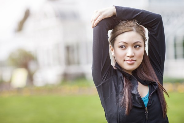 Asian woman with arms above her head