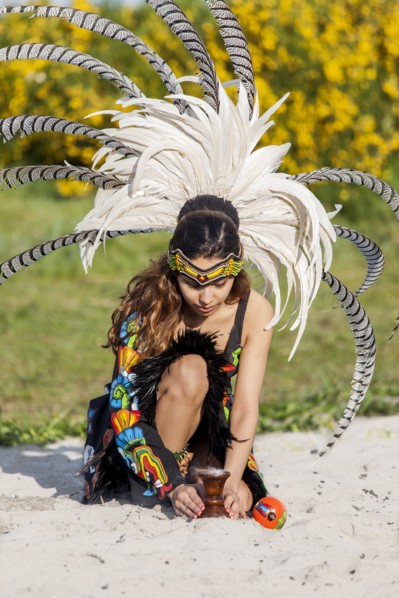 Native American woman in traditional headdress performing ceremony