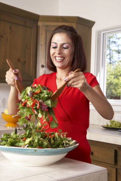 Hispanic woman tossing salad