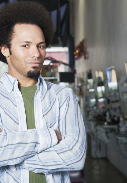 Mixed Race male hair stylist with arms crossed