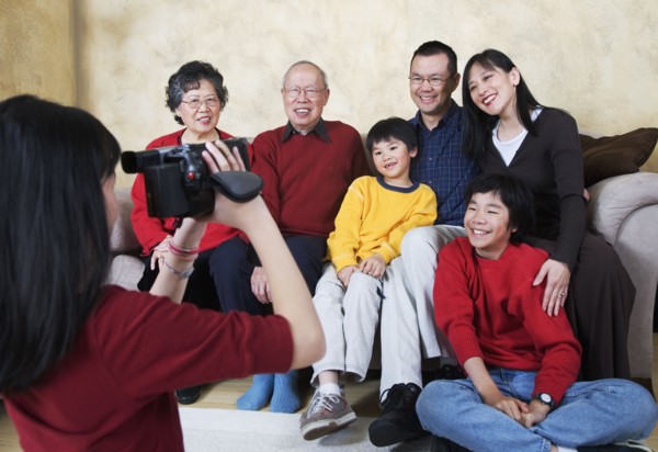 Multi-generational Asian family being video recorded