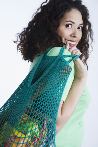 Mixed race woman holding reusable grocery bag