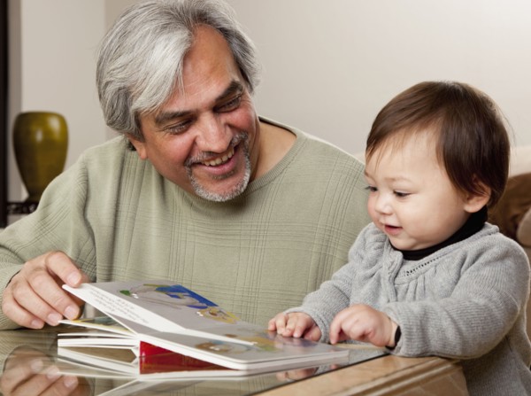 Grandfather reading book to granddaughter