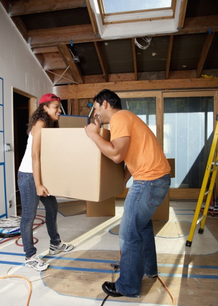 Hispanic couple carrying cardboard box
