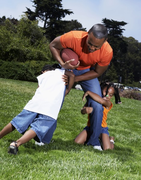 Father and children playing in park