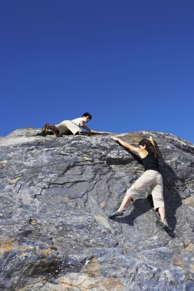 Climbers scaling steep rock face