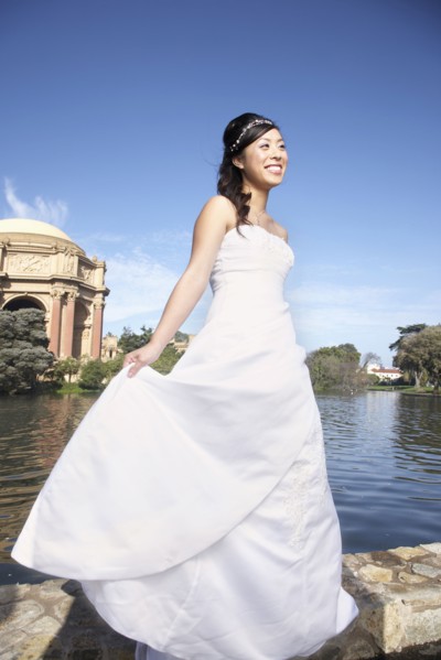 Chinese bride smiling in urban park