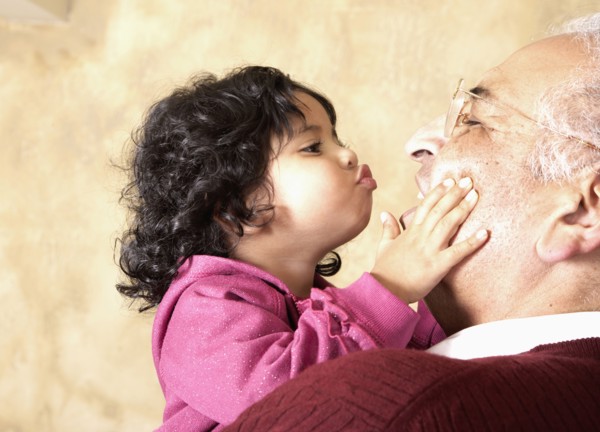 Hispanic girl kissing grandfather