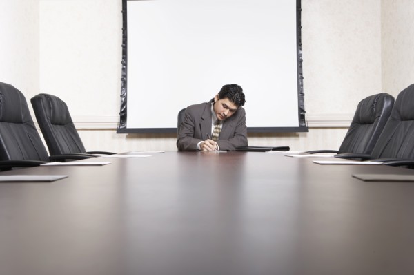 Mixed race businessman sitting at conference table