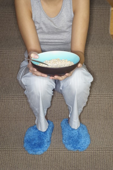 Asian woman eating cereal on stairs