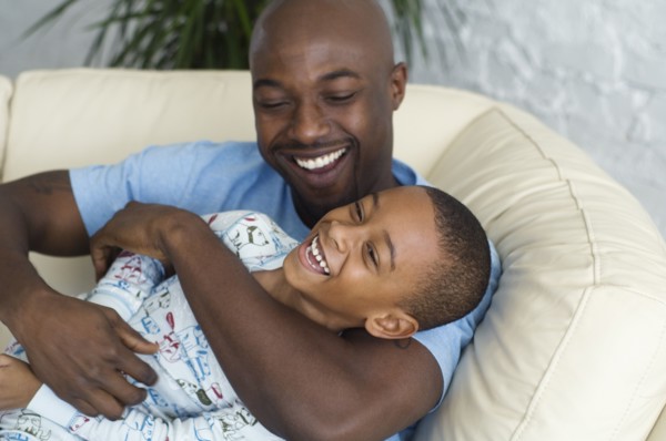 African father tickling son