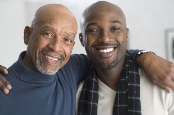 African father and adult son hugging