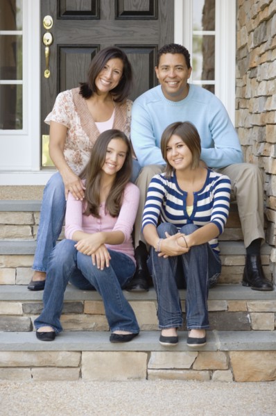 Hispanic family sitting on porch steps
