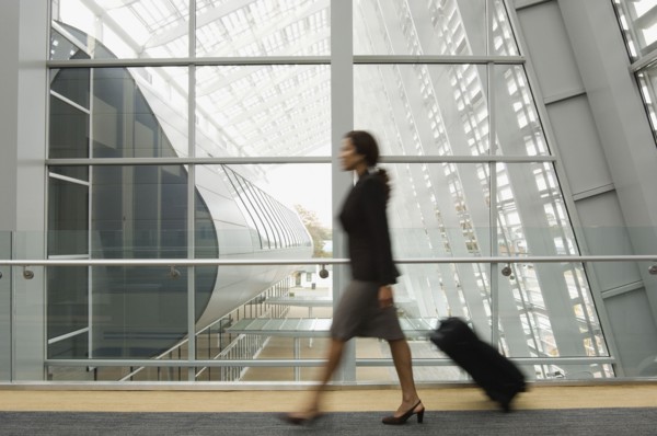 Hispanic businesswoman pulling suitcase