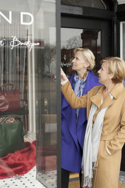 Older Caucasian women window shopping in clothing store