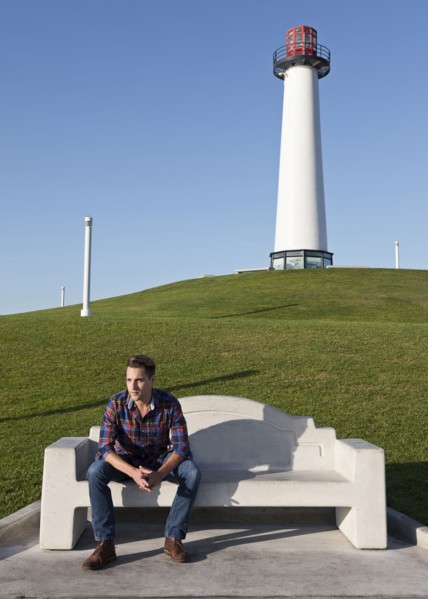 Man sitting on park bench near lighthouse