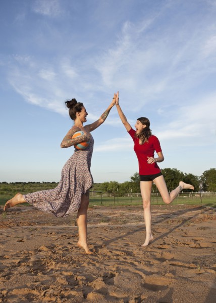 Caucasian women high fiving in rural field
